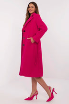Woman wearing a bright pink coat on a white background