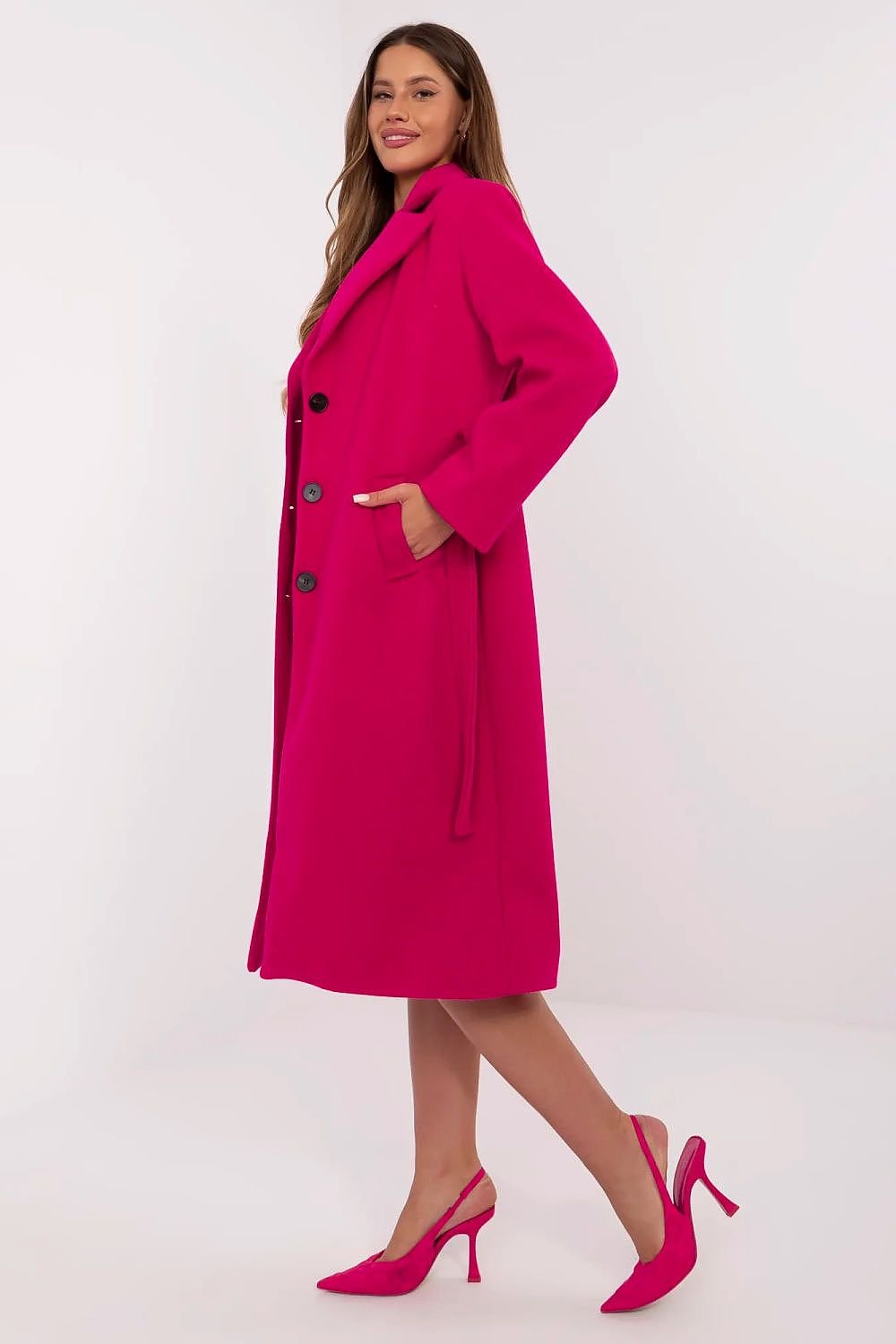 Woman wearing a bright pink coat on a white background
