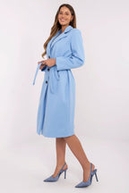 Woman wearing a light blue coat with a white background