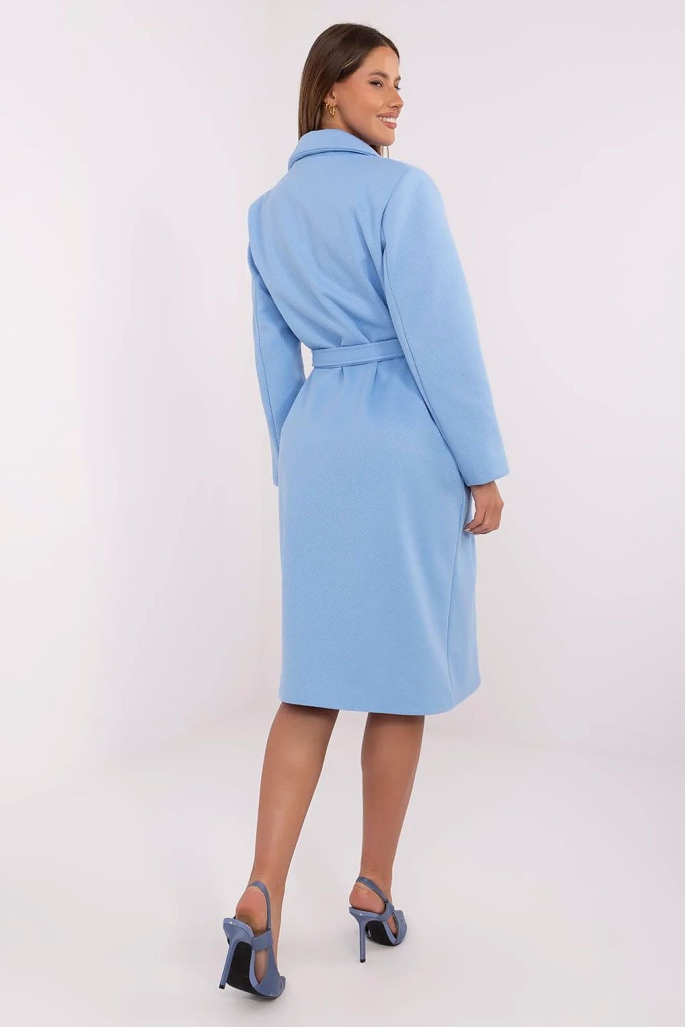 Woman wearing a light blue coat on a white background