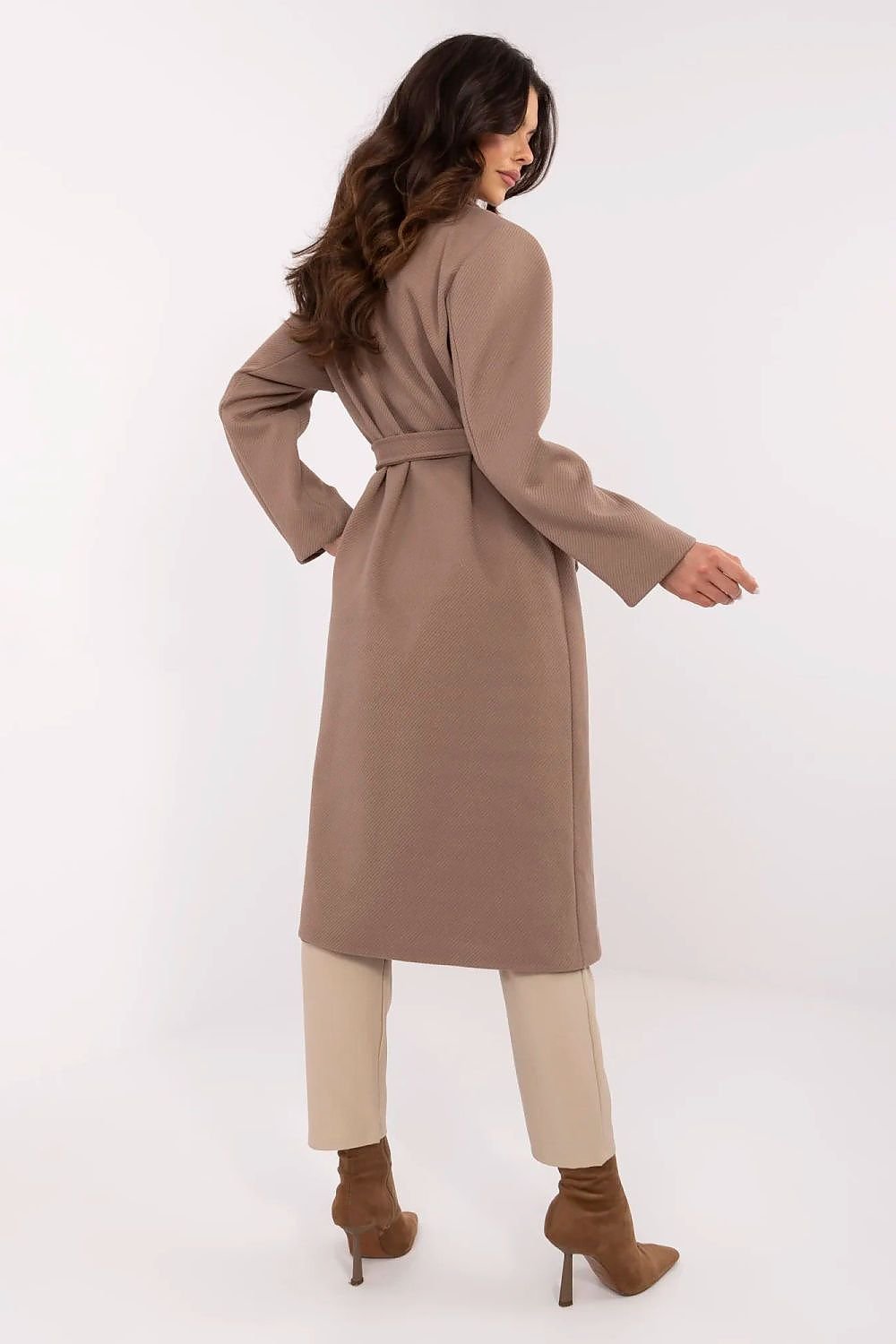 Woman wearing a long beige coat on a white background
