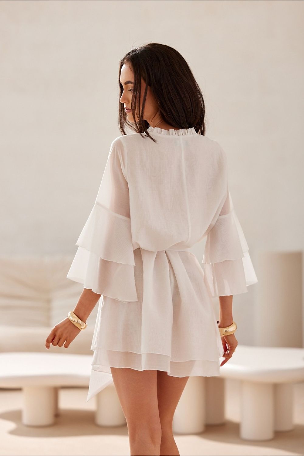 Woman wearing a white outfit in a minimalistic setting