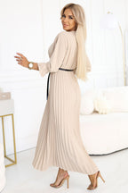 Woman wearing a beige pleated dress on a white background