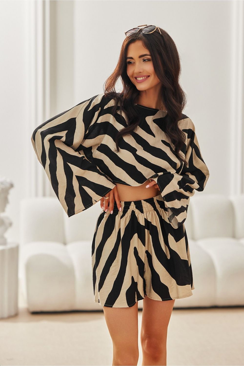 Woman wearing a zebra print outfit in a bright room