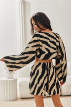 Woman wearing a zebra print outfit in a minimalistic room.