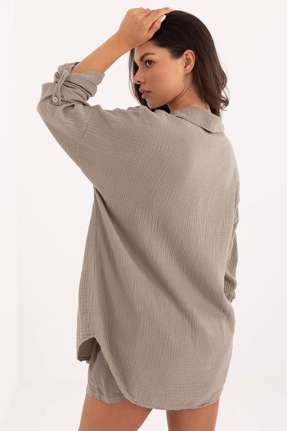 Woman wearing a beige ribbed dress on a white background