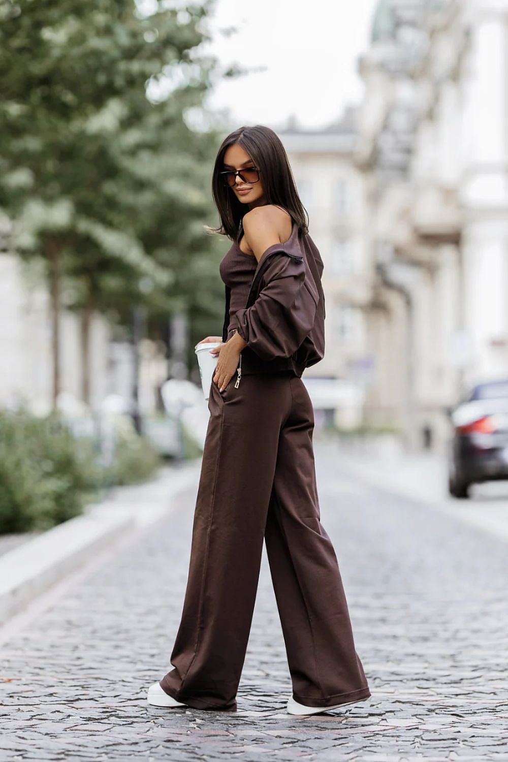 Woman in a brown outfit walking on a street