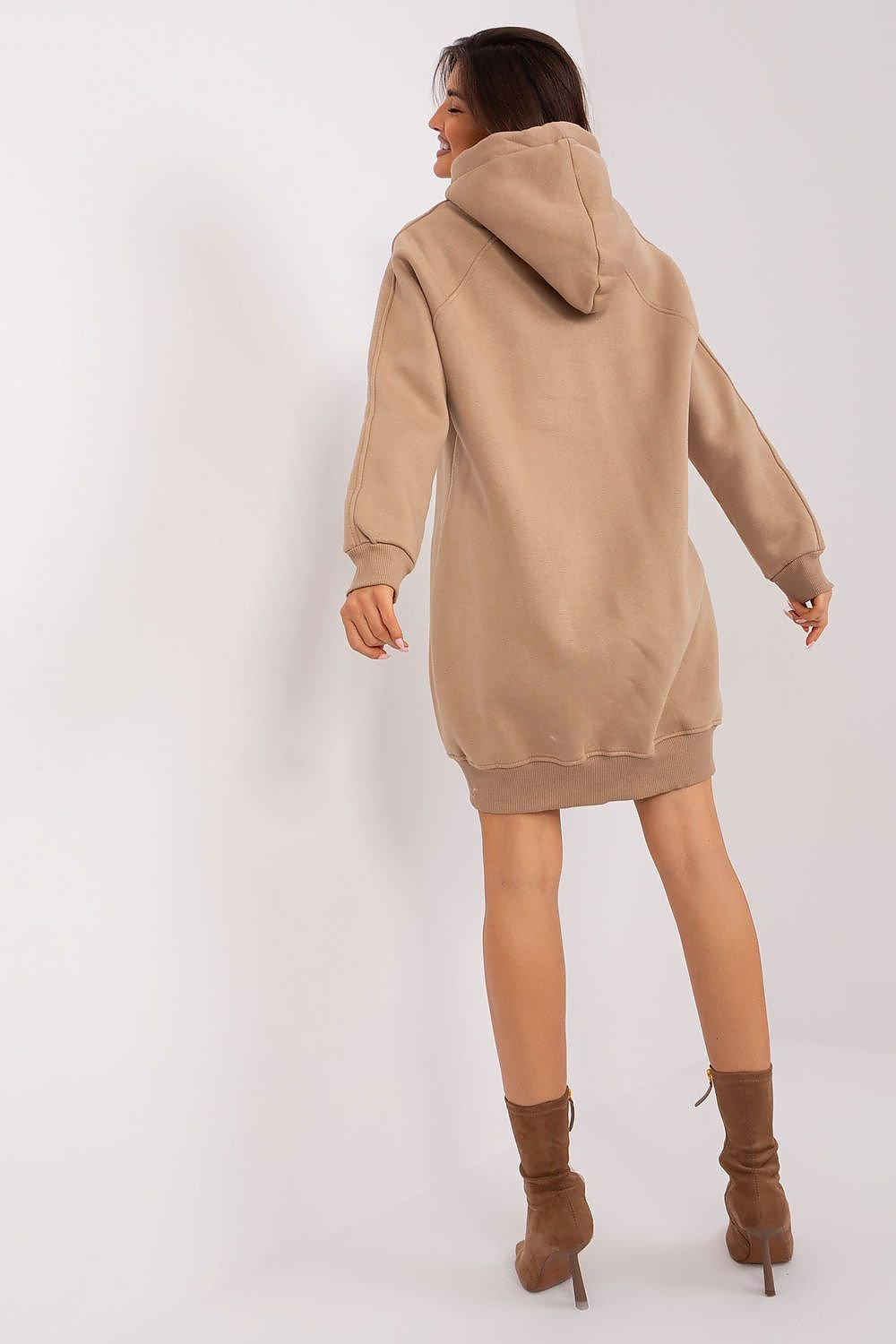 Woman wearing a beige hoodie dress on a white background