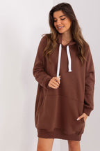 Woman wearing a brown hoodie dress against a white background