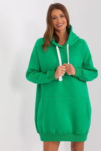 Woman wearing a green hoodie dress against a white background