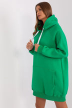 Woman wearing a green hoodie dress against a white background