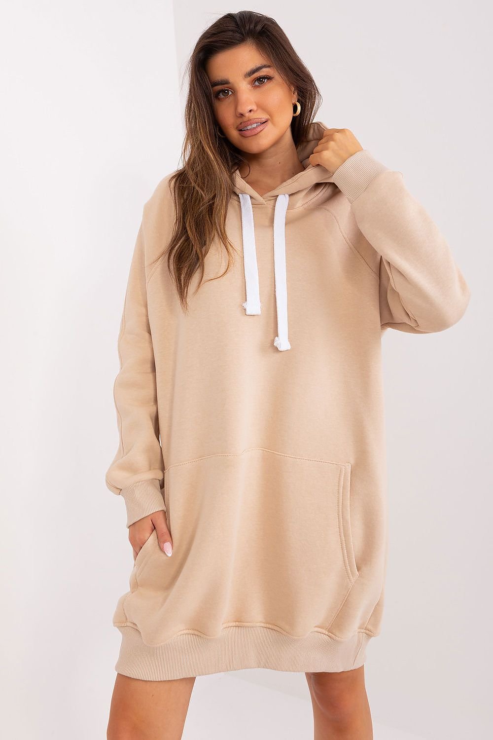 Woman wearing a beige hoodie with a white background