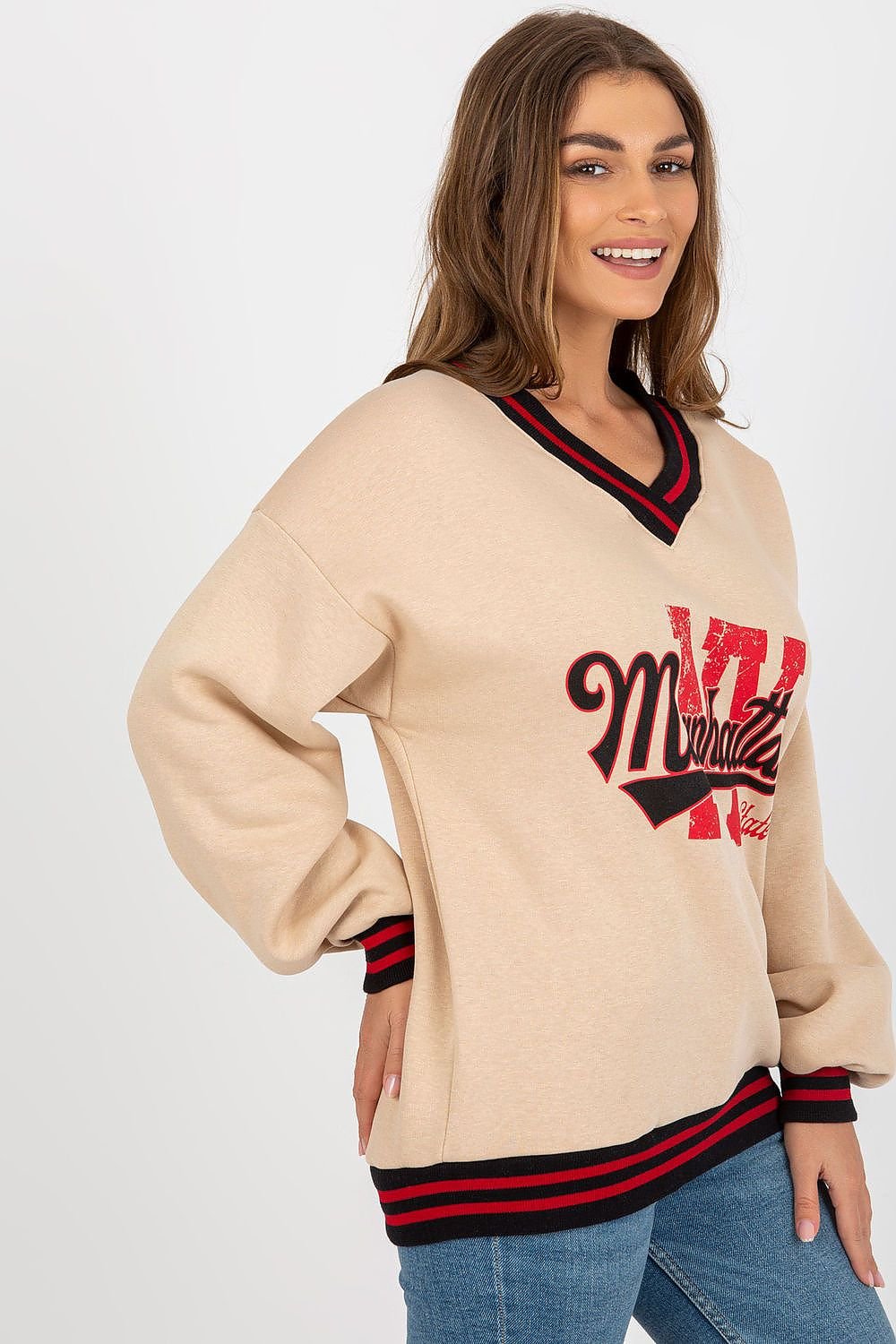 Woman wearing a beige sweater with red and black text on a white background