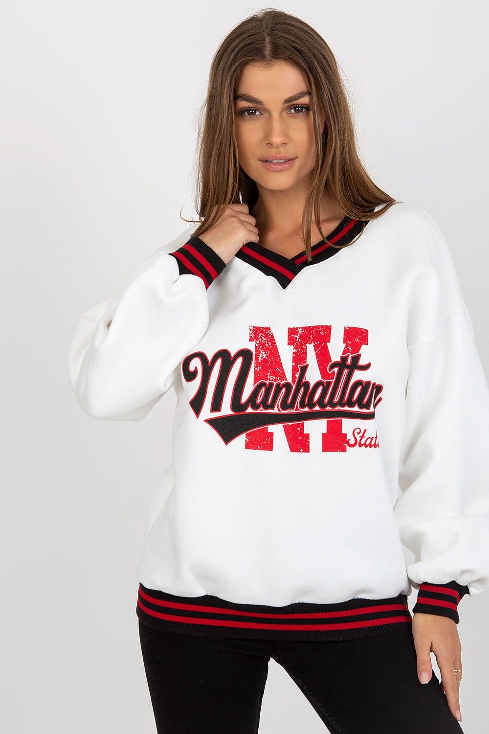 Woman wearing a white sweatshirt with red and black text on a plain background