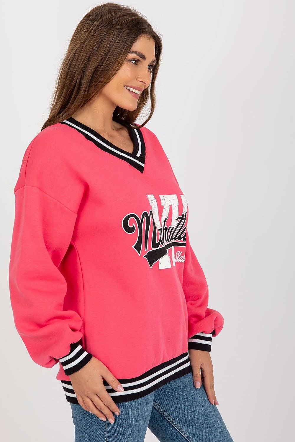 Woman wearing a pink sweatshirt with 'Mitchell' logo on a white background