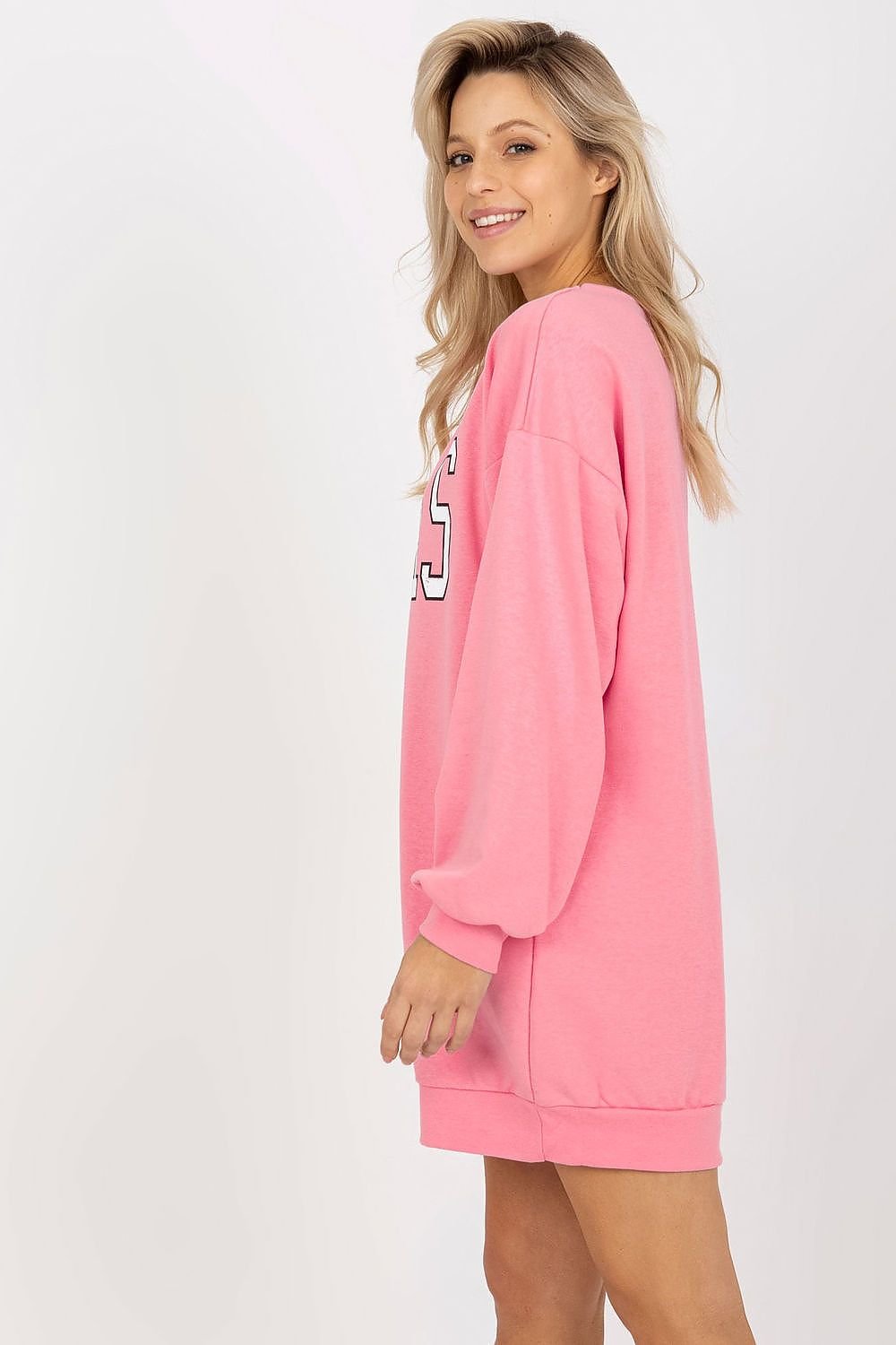 Woman wearing a pink cardigan over a white top on a white background