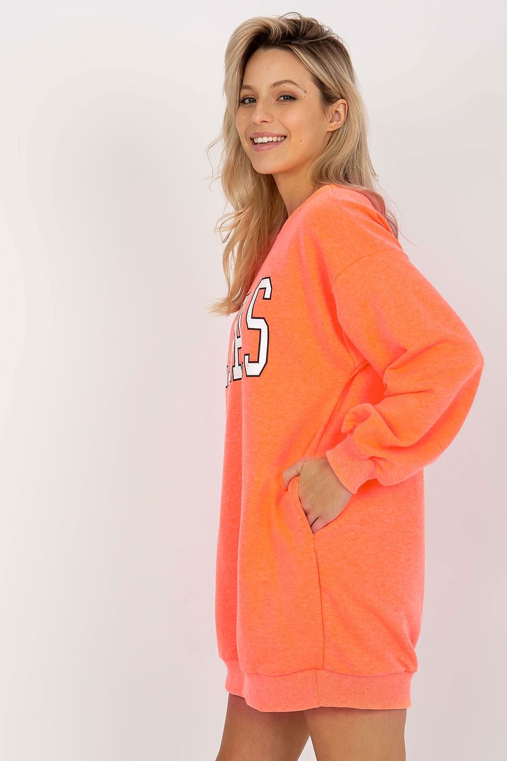 Woman wearing a bright orange hoodie with text on a white background