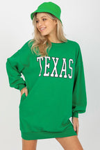 Person wearing a green 'TEXAS' sweatshirt and green cap on a white background