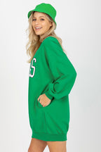 Woman wearing a green sweatshirt and cap on a white background