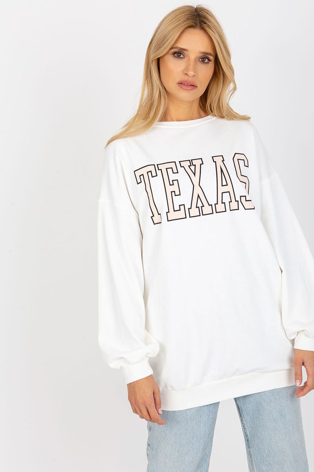 Woman wearing a white sweatshirt with 'TEXAS' printed on it against a white background