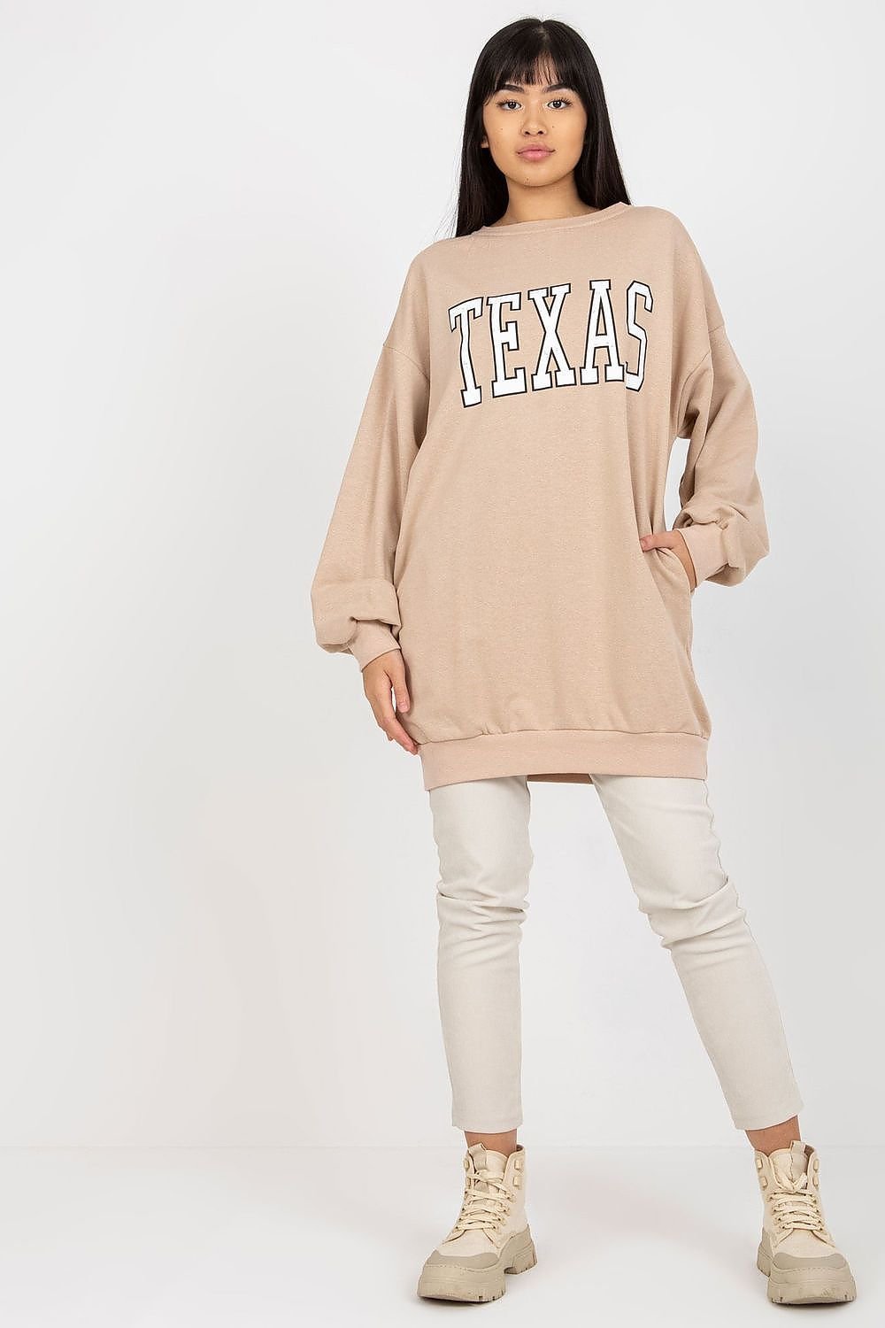 Woman wearing a beige 'Texas' sweatshirt on a white background