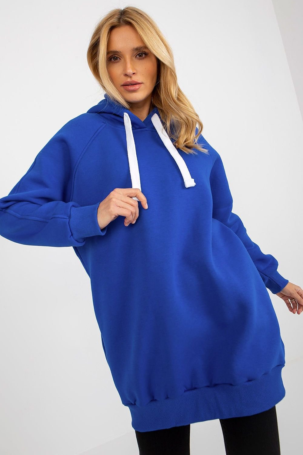 Woman wearing a blue hoodie with white drawstrings on a white background