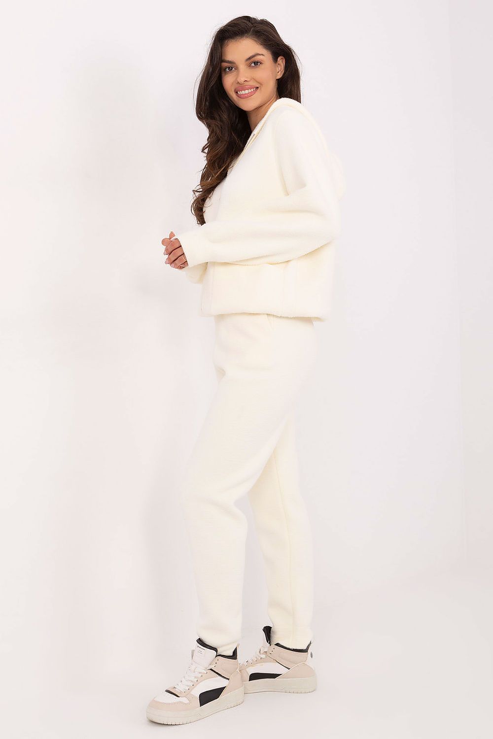 Woman wearing a white outfit with a plain background