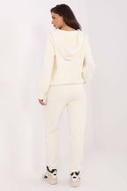 Person wearing a cream-colored hoodie and pants on a white background