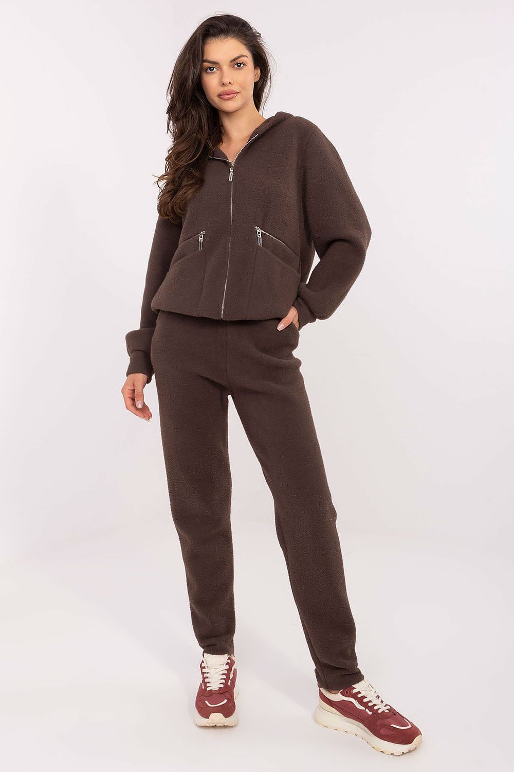 Woman wearing a brown tracksuit on a white background
