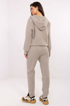 Person wearing a beige tracksuit on a white background