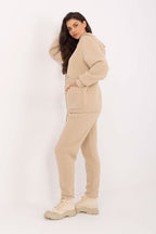 Woman wearing a beige tracksuit on a white background