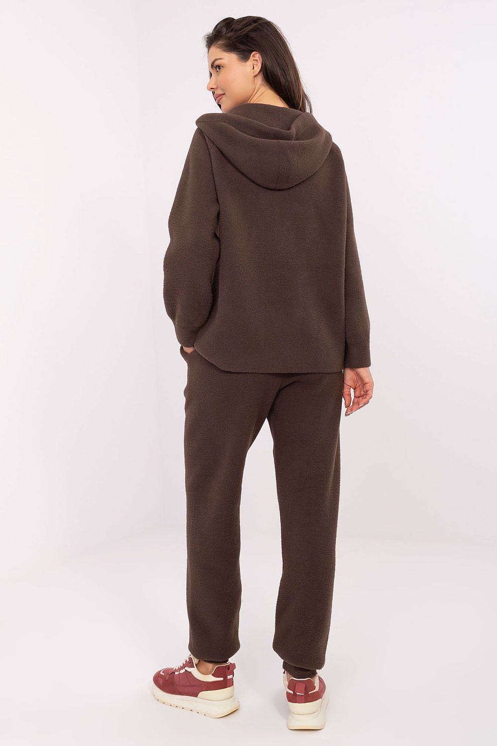 Person wearing a brown tracksuit on a white background