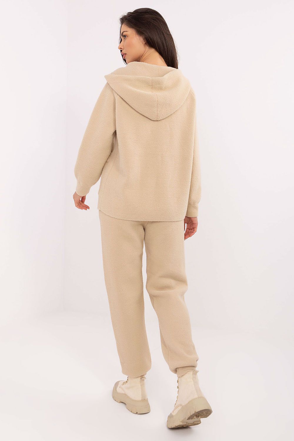 Woman wearing a beige tracksuit on a white background