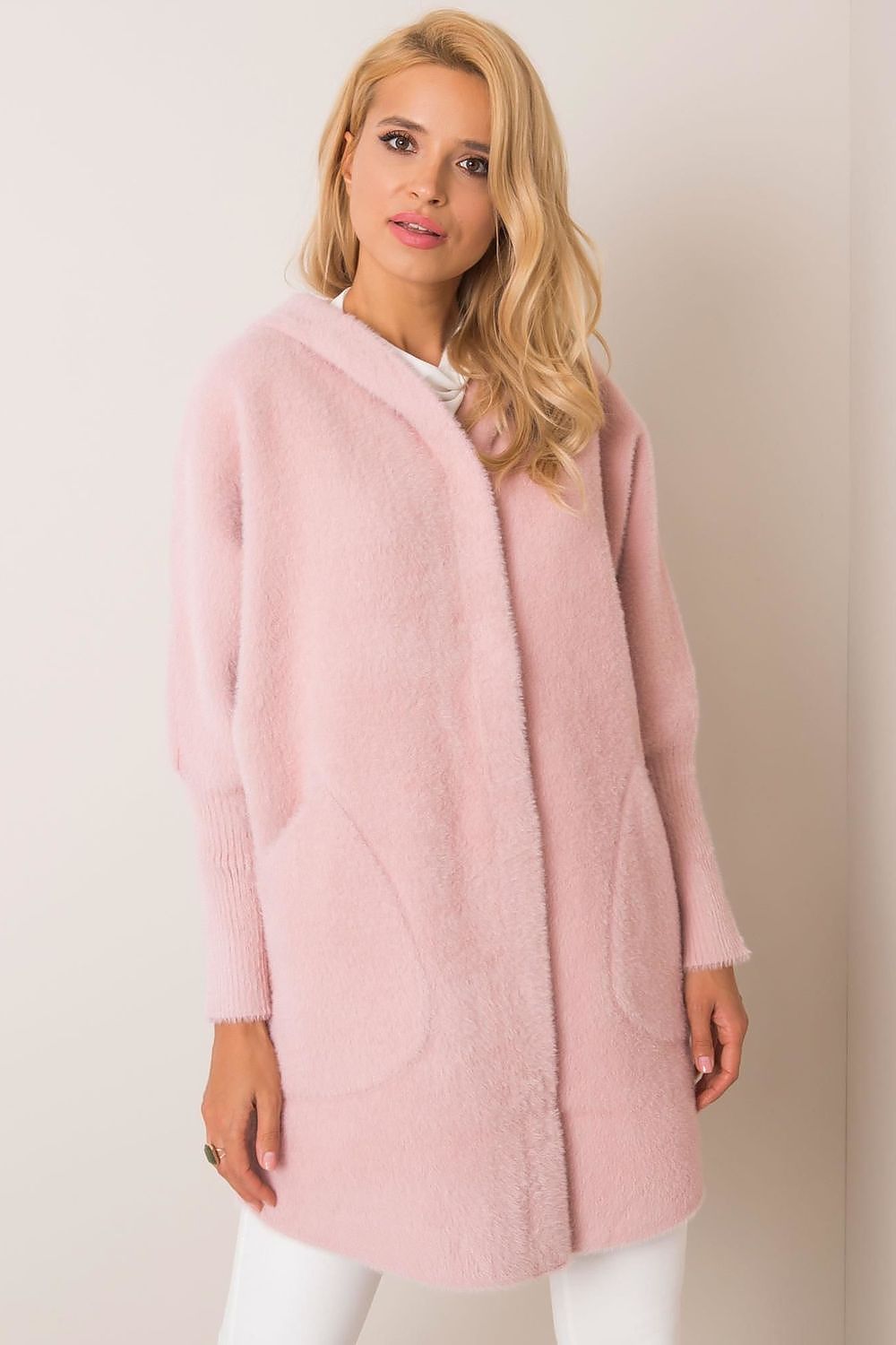 Woman wearing a pink coat against a plain background