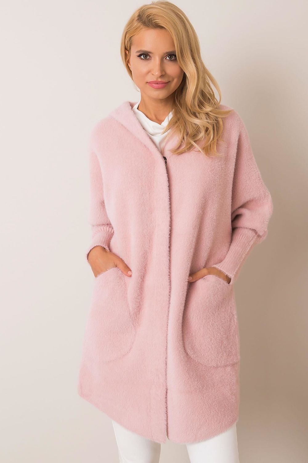 Woman wearing a pink coat with a plain background