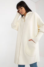 Person wearing a cream-colored coat on a white background