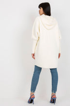 Woman wearing a white hooded coat and blue jeans on a white background