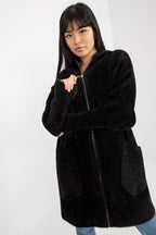 Woman wearing a black coat with a white background