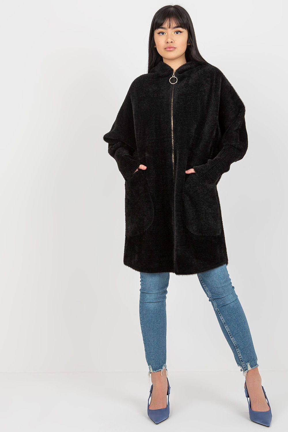Person wearing a black hooded coat and blue jeans on a white background