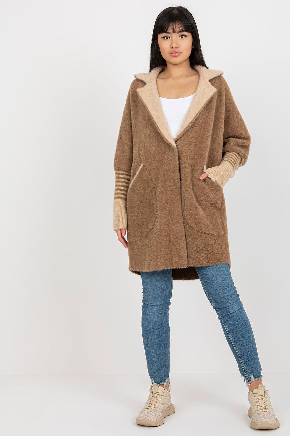 Woman wearing a brown coat with beige lining on a white background