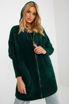 Woman wearing a green hooded coat against a white background
