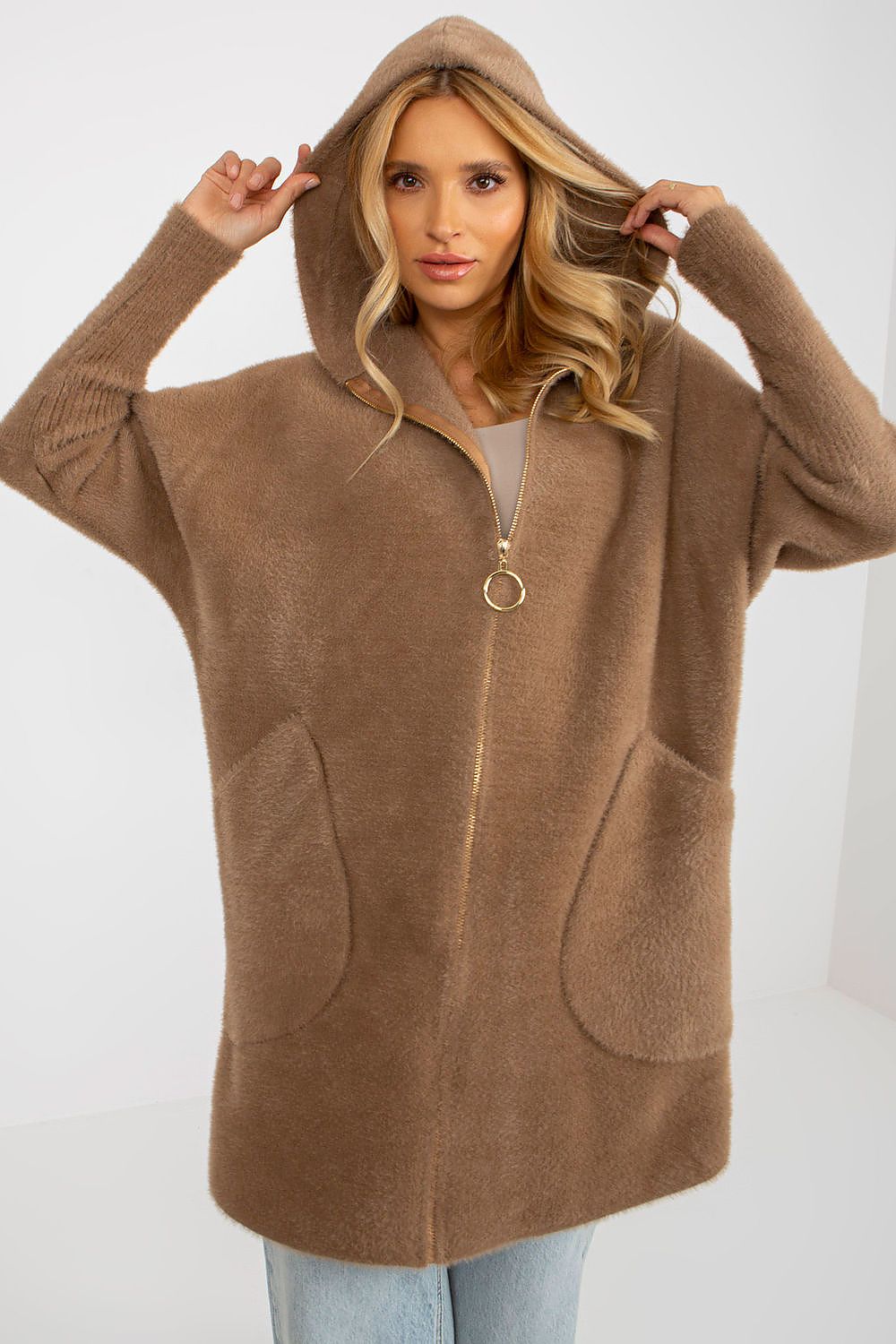 Woman wearing a brown hooded sweater against a white background