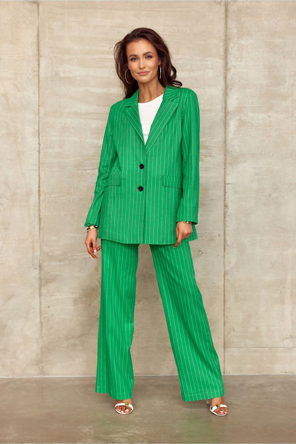 Woman wearing a green pinstripe suit against a neutral background