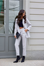 Woman in a stylish outfit standing outside a building