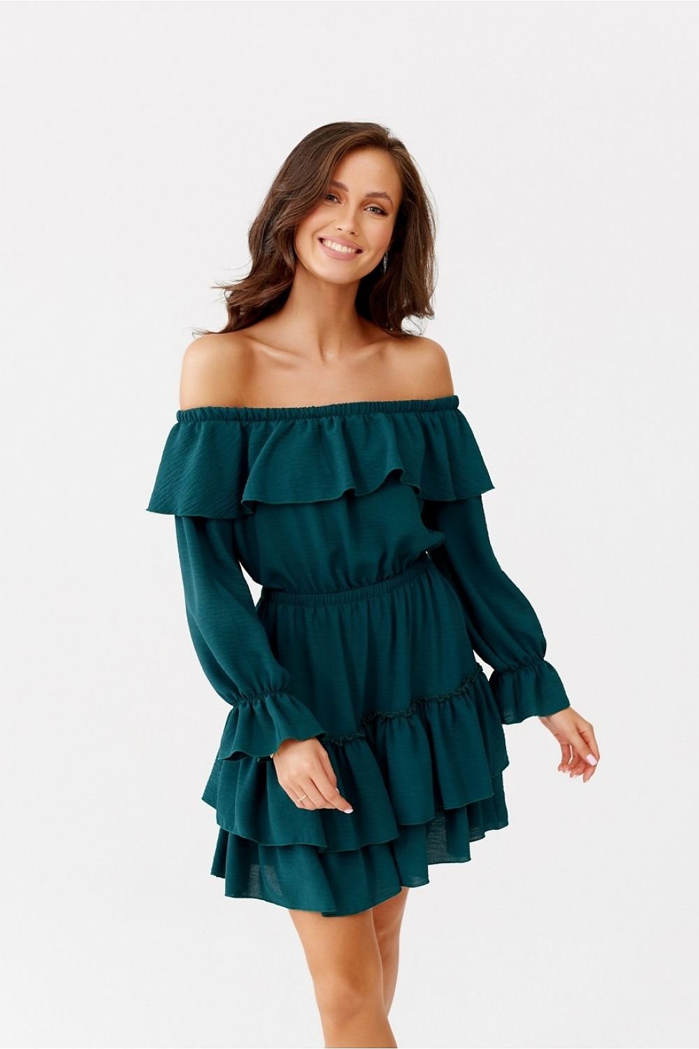 Woman wearing a teal off-shoulder dress on a white background