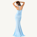 Graceful woman in a light blue Evelyn Belluci evening gown with a deep plunge neckline and flowing silhouette — perfect for weddings, galas, and elegant events.