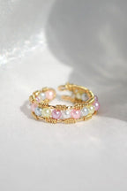 Stack of gold and pearl rings on a white background