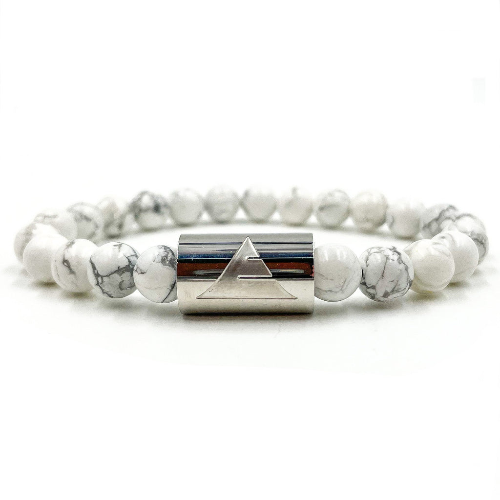 Bracelet with white beads and silver cylindrical clasp on a white background
