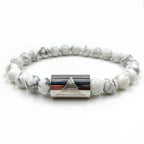 Bracelet with white beads and silver cylindrical clasp on a white background