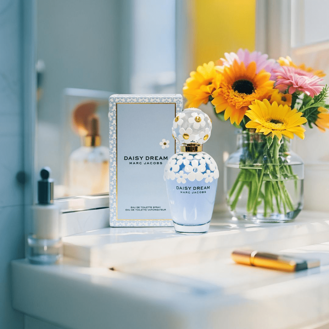 "Marc Jacobs Daisy Dream Eau de Toilette 3.4 oz – a sky-blue glass bottle adorned with delicate white daisies on the cap and shoulders, reflecting a dreamy and feminine design."